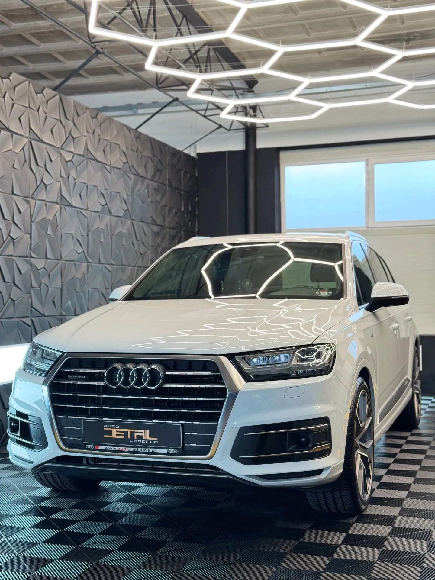Biele Audi Q7 v štúdiu po aplikácii PPF fólie na prednú časť a keramickej ochrane laku