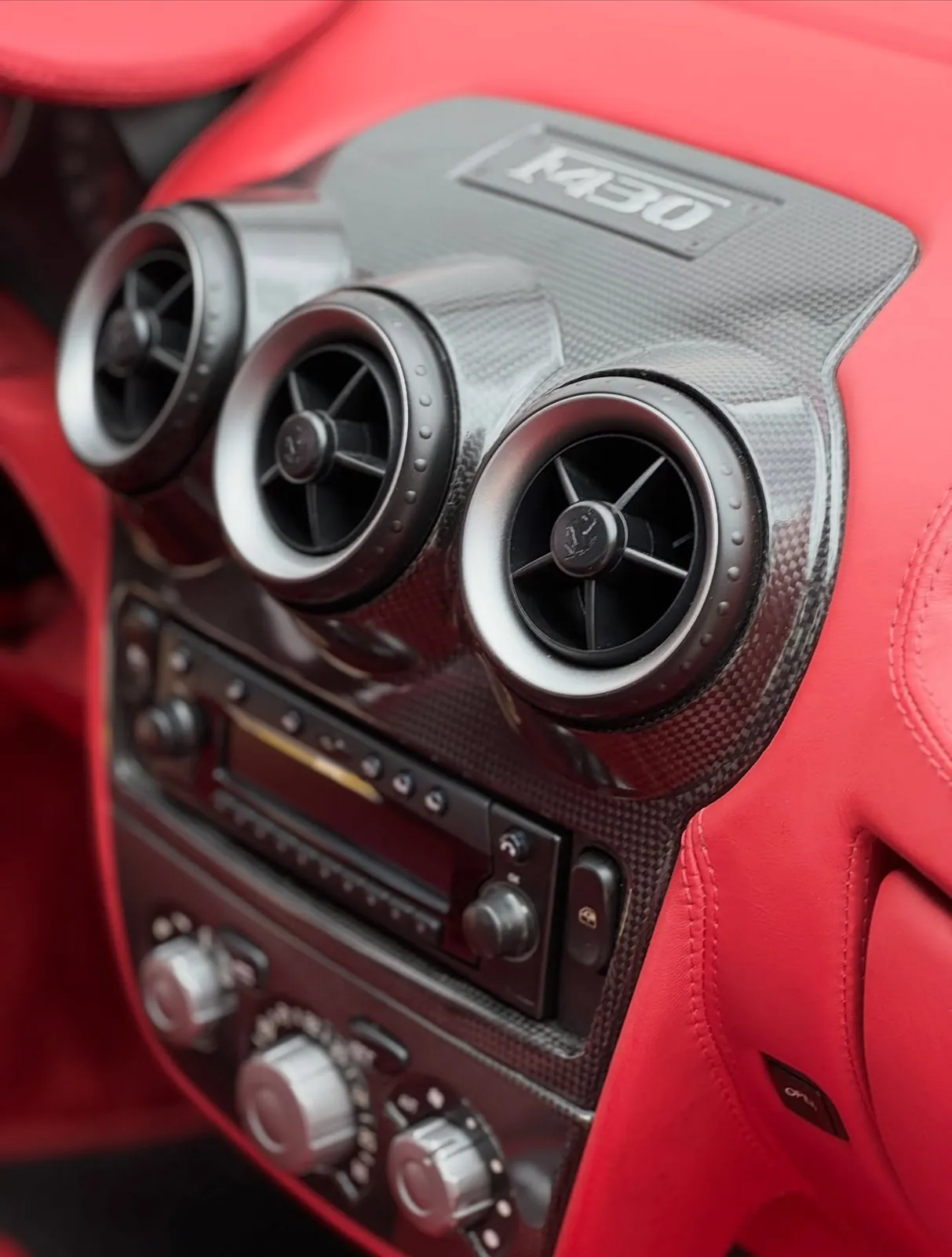 Vyčistená karbónová konzola a výduchy v interiéri Ferrari F430